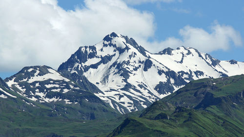 Low angle view of snowcapped mountains against sky