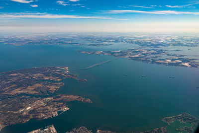 Aerial view of city by sea against sky