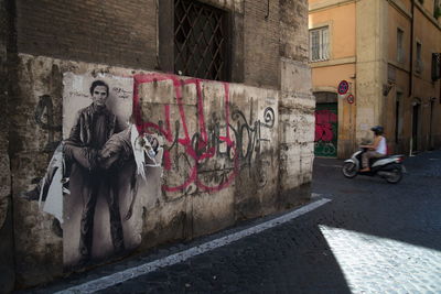 Man sitting on wall in city