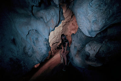 Woman sitting against rocks