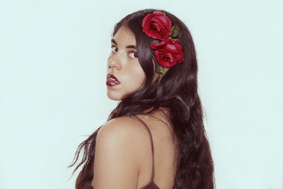 Portrait of woman with roses against white background