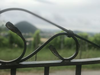 Close-up of wet fence against sky