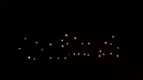 Close-up of illuminated lights over black background