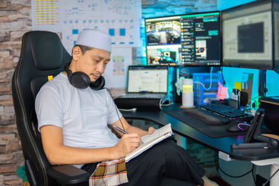 Young man using mobile phone while sitting on table