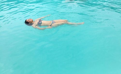 High angle view of woman in bikini swimming in pool