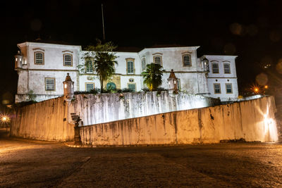 Street by buildings in city at night