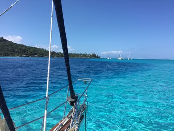 Sailboat sailing in sea against clear blue sky