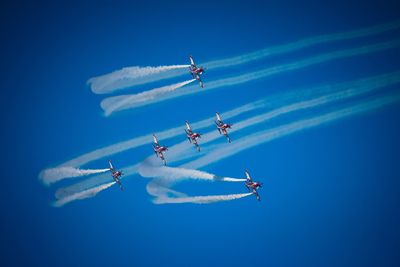 Low angle view of airplane flying against blue sky