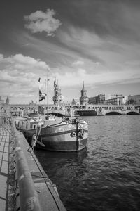 Ship moored in sea against cloudy sky