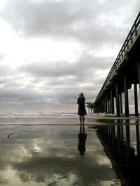 Full length of man walking on beach against sky