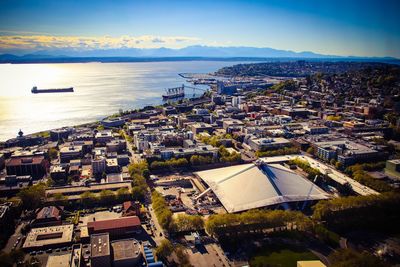 High angle view of city by sea against sky