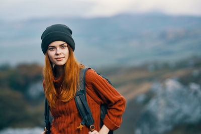 Portrait of young woman standing in park during winter