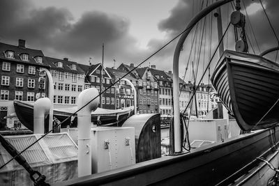 Sailboats moored in city against sky