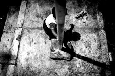 Low section of man standing on cobblestone street