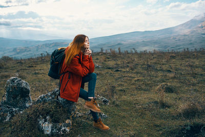 Woman on mountain against sky