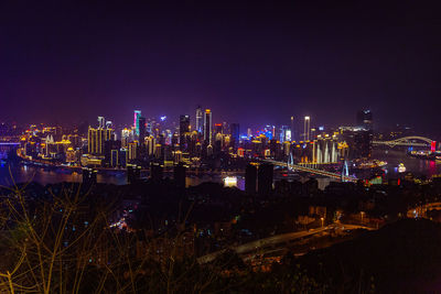 Illuminated cityscape against sky at night