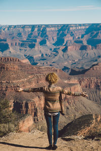 Rear view of woman standing on desert