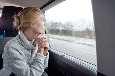 Young woman looking out car window