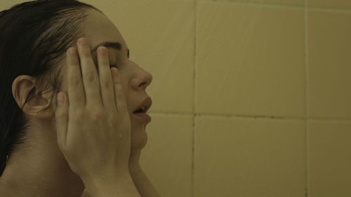 Portrait of young woman against wall