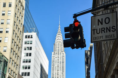 Low angle view of road signal against buildings in new york