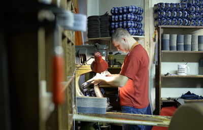 Shoemaker working on slippers in workshop