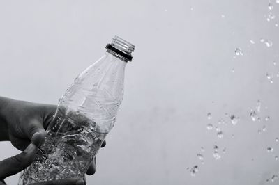 Cropped hand splashing water from bottle