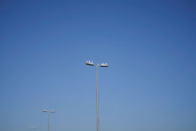 Low angle view of floodlight against clear blue sky