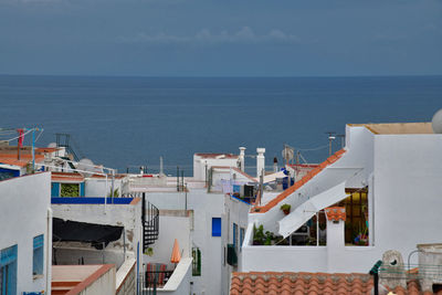 High angle view of buildings by sea against sky