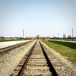 Railroad tracks at auschwitz concentration camp against clear sky