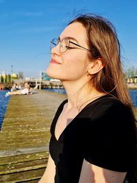 Portrait of woman at pier against sky