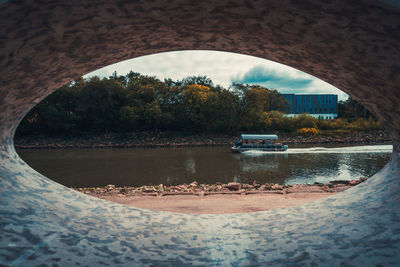 Reflection of trees on bridge against sky