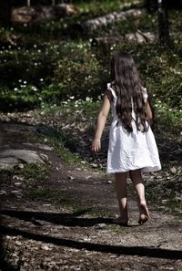 Rear view of girl walking on footpath