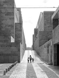 Rear view of people walking on road against sky