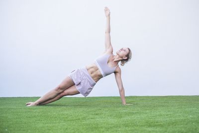 Midsection of woman with arms raised on field