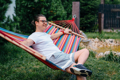 Man sitting on hammock in field