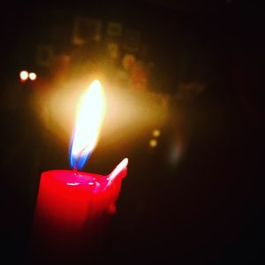 Close-up of lit candle in dark room