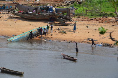 High angle view of people by dugout canoes on river