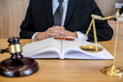 Midsection of man reading book