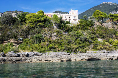 Scenic view of sea by buildings against sky