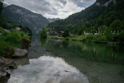 Scenic view of lake by mountains against sky