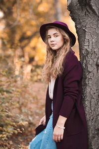 Young woman leaning on tree