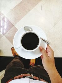 Directly above shot of hand holding coffee cup