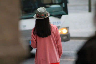 Rear view of woman wearing sun hat while walking on city street