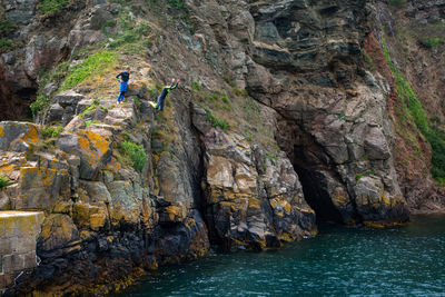 Children diving in sea from cliff