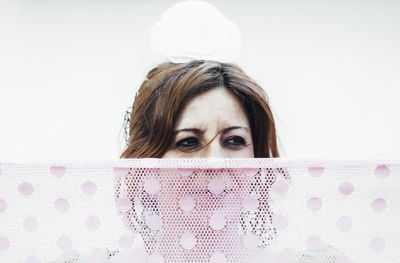 Portrait of young woman against white background