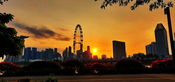 Modern buildings against sky during sunset