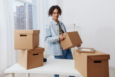 Side view of man using digital tablet while standing in box