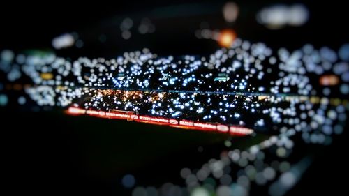 Close-up of wet illuminated lights at night