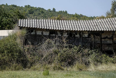 Abandoned house on field against sky