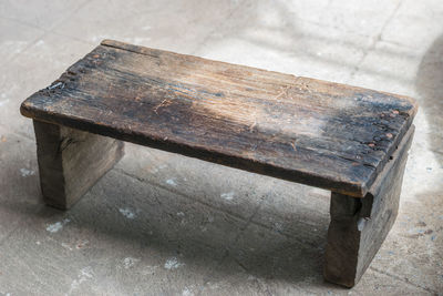 High angle view of old wooden seat on walkway